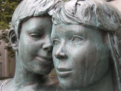 Sculpture of boy whispering to woman
