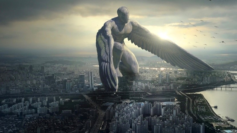 The image shows a huge stone angel guarding a city within its two wings.